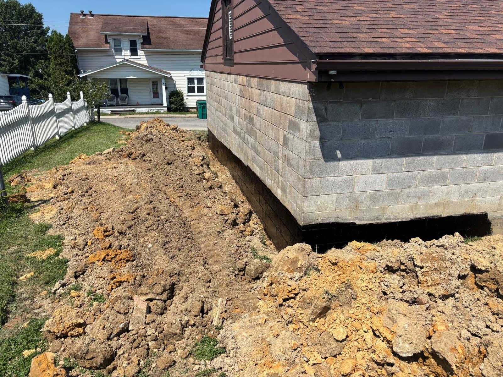 Foundation excavation and waterproofing along a block garage wall in Bridgeport, WV